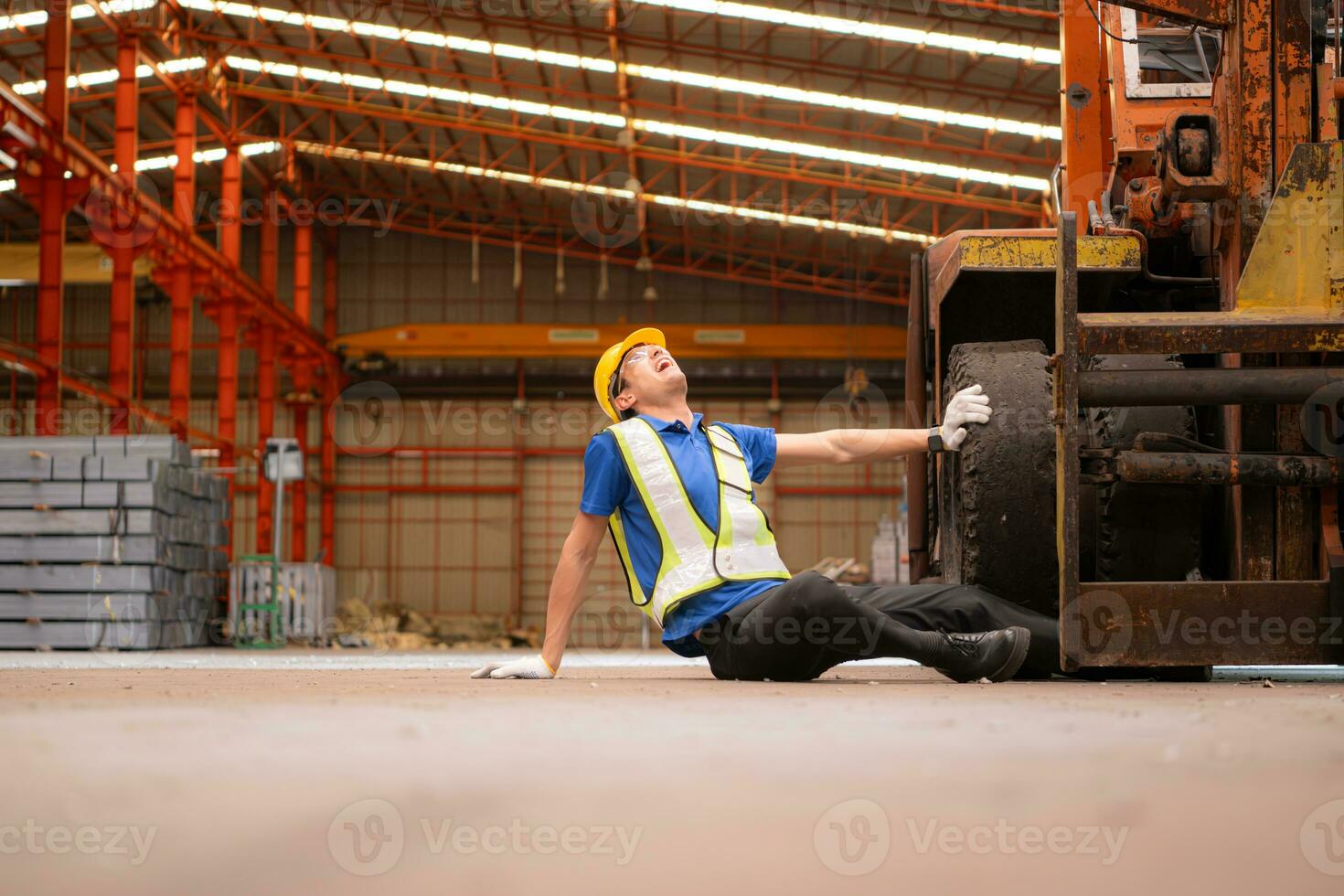 Young man working in a steel industry factory. He was critically hurt when a forklift ran over his leg and had to be transported to the hospital. photo