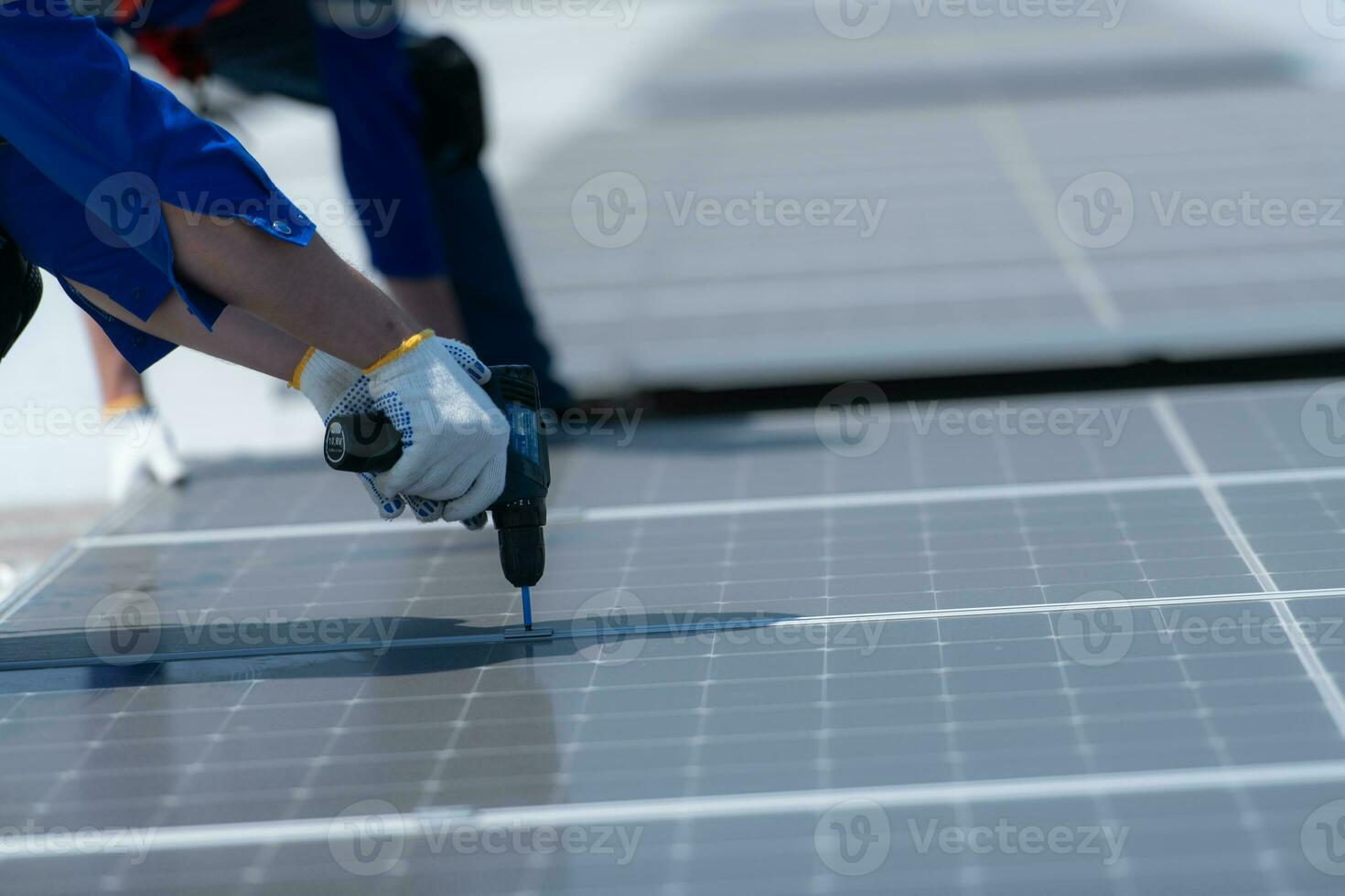 Both of technicians is installing solar panels on the roof of the warehouse to change solar energy into electrical energy for use in factories. photo