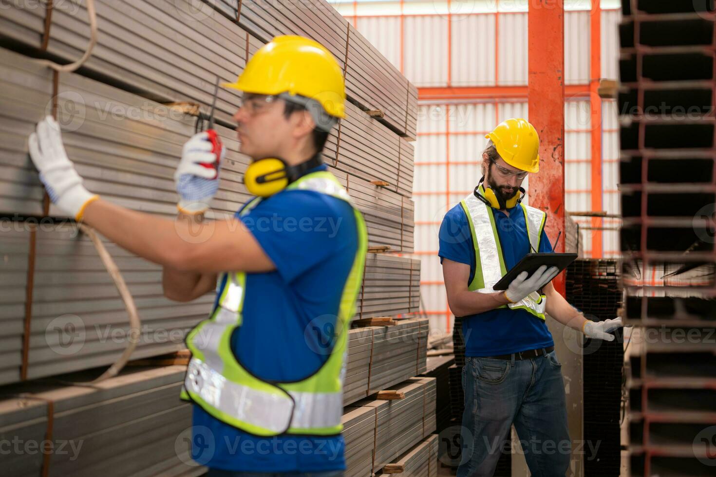 Warehouse workers in hard hats and helmets stand in the warehouse to count and inspect the steel in the warehouse. photo