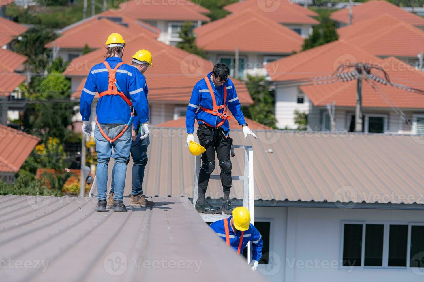 After installing and inspecting the performance of the solar cell panels on the factory roof, a group of engineers installing solar panels descends the stairs to go home photo