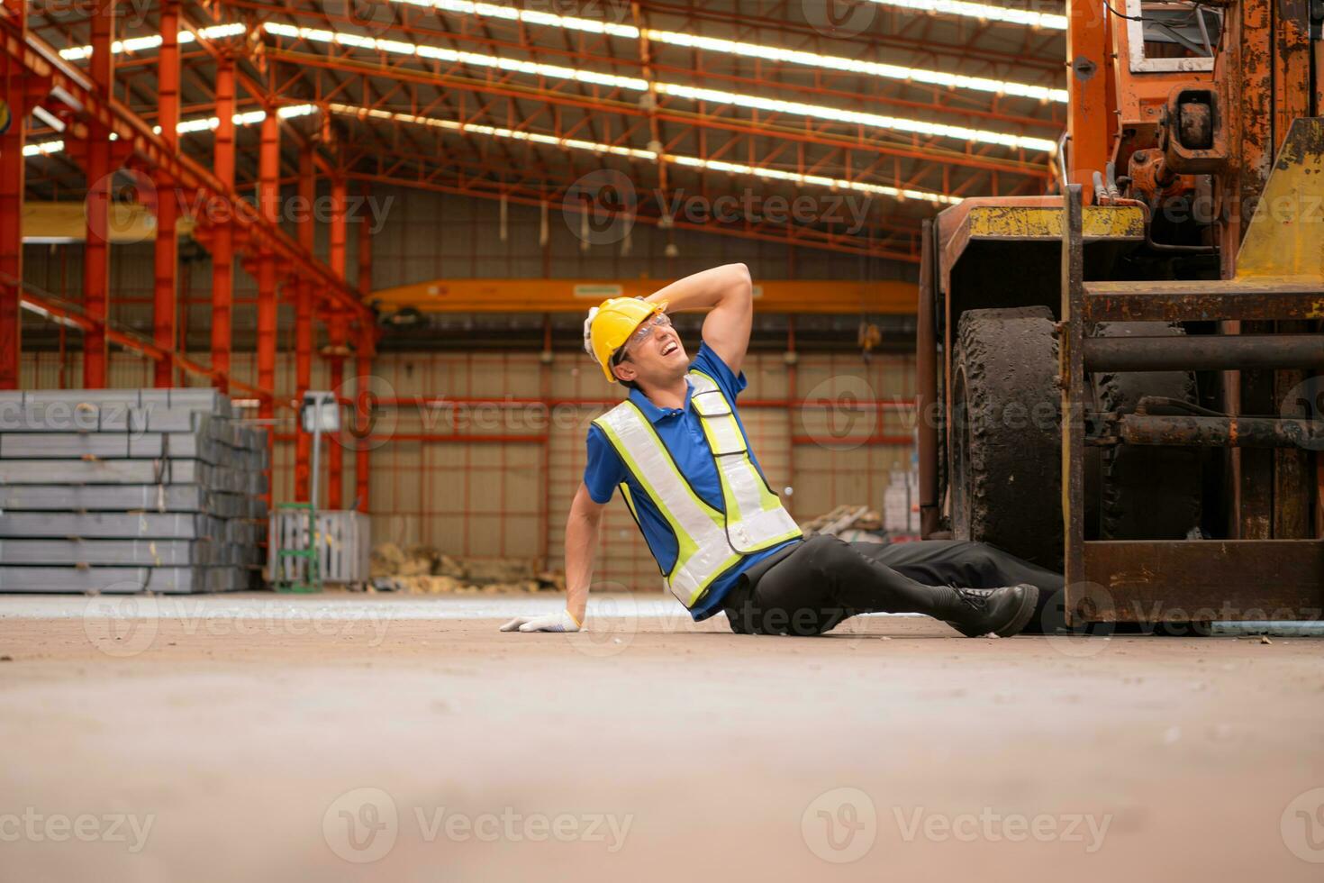 Young man working in a steel industry factory. He was critically hurt when a forklift ran over his leg and had to be transported to the hospital. photo