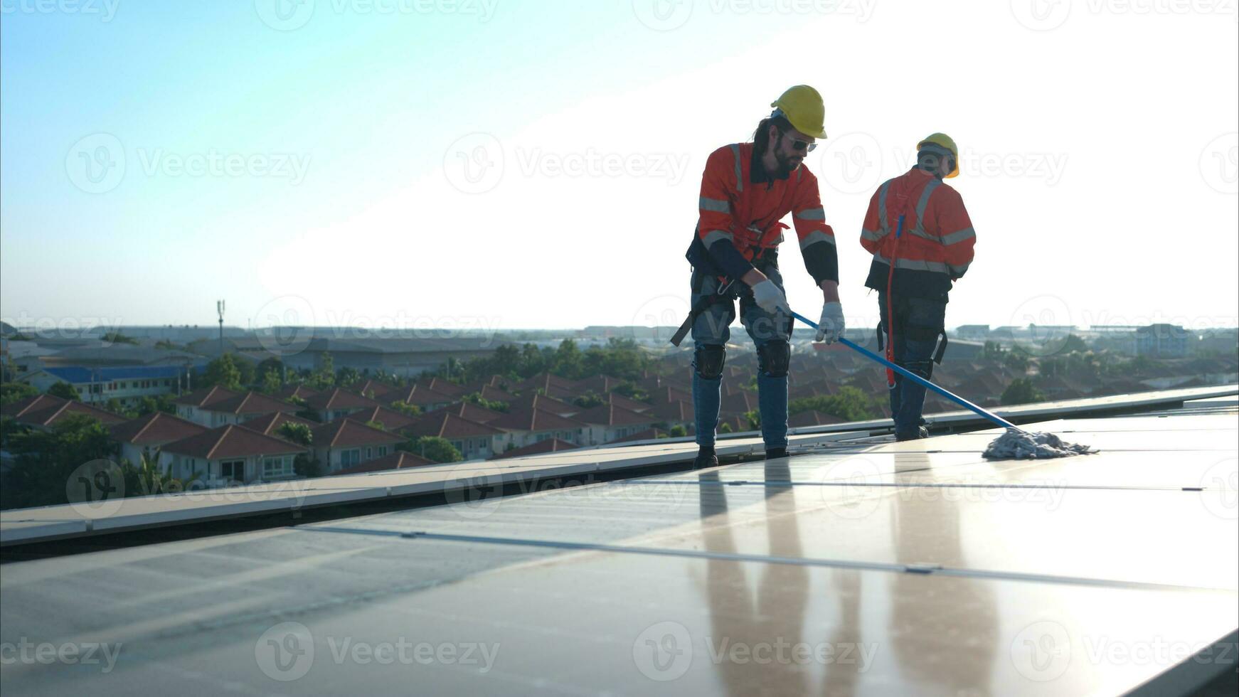 Engineer and technician working on the solar panel on the warehouse roof to inspect the solar panels that have been in operation for some time. photo