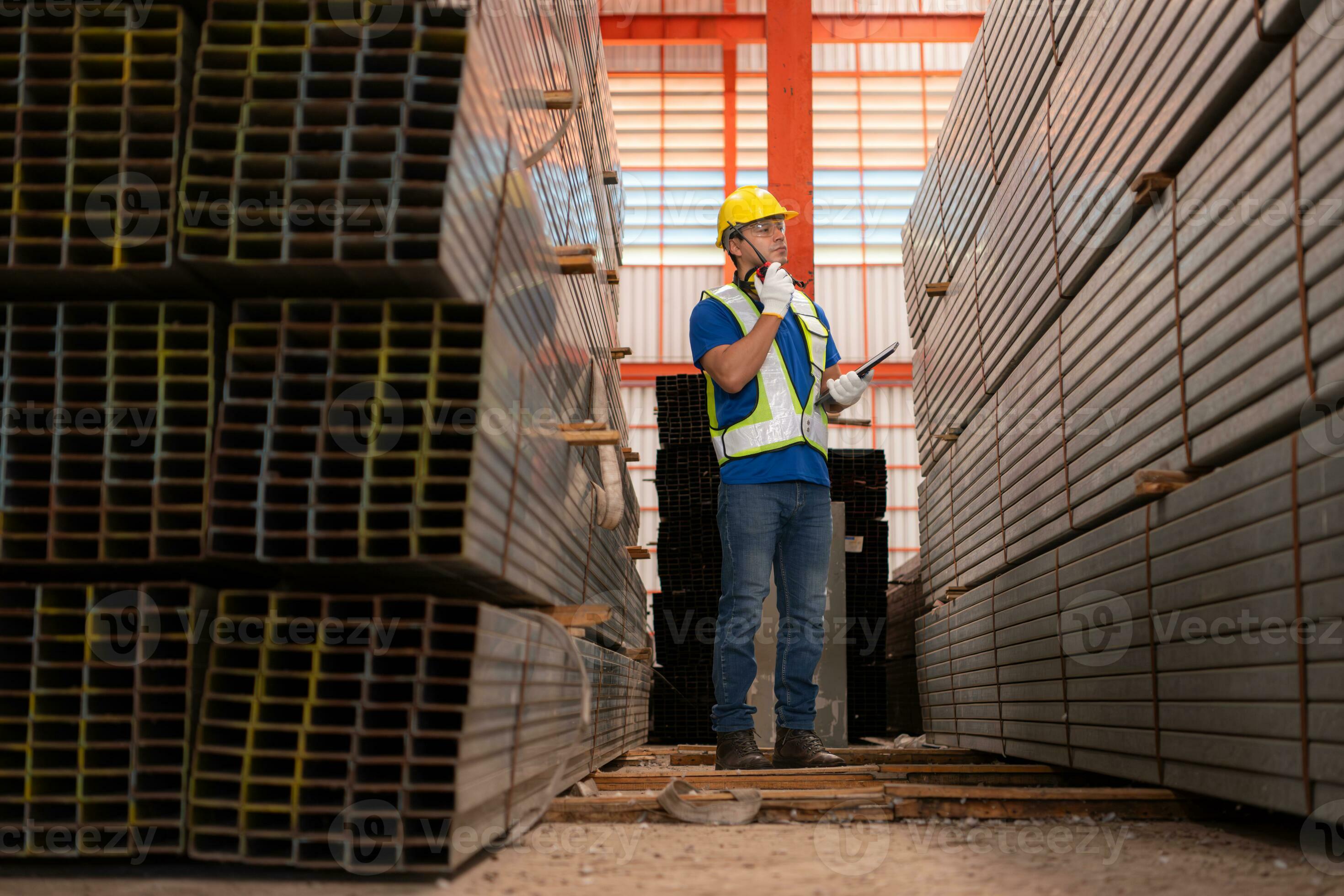 Warehouse worker in hard hats and helmets stand in the warehouse to