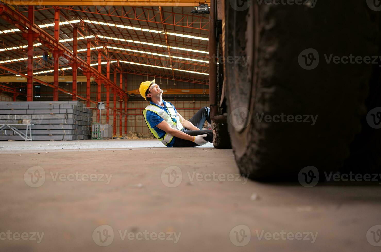 Young man working in a steel industry factory. He was critically hurt when a forklift ran over his leg and had to be transported to the hospital. photo