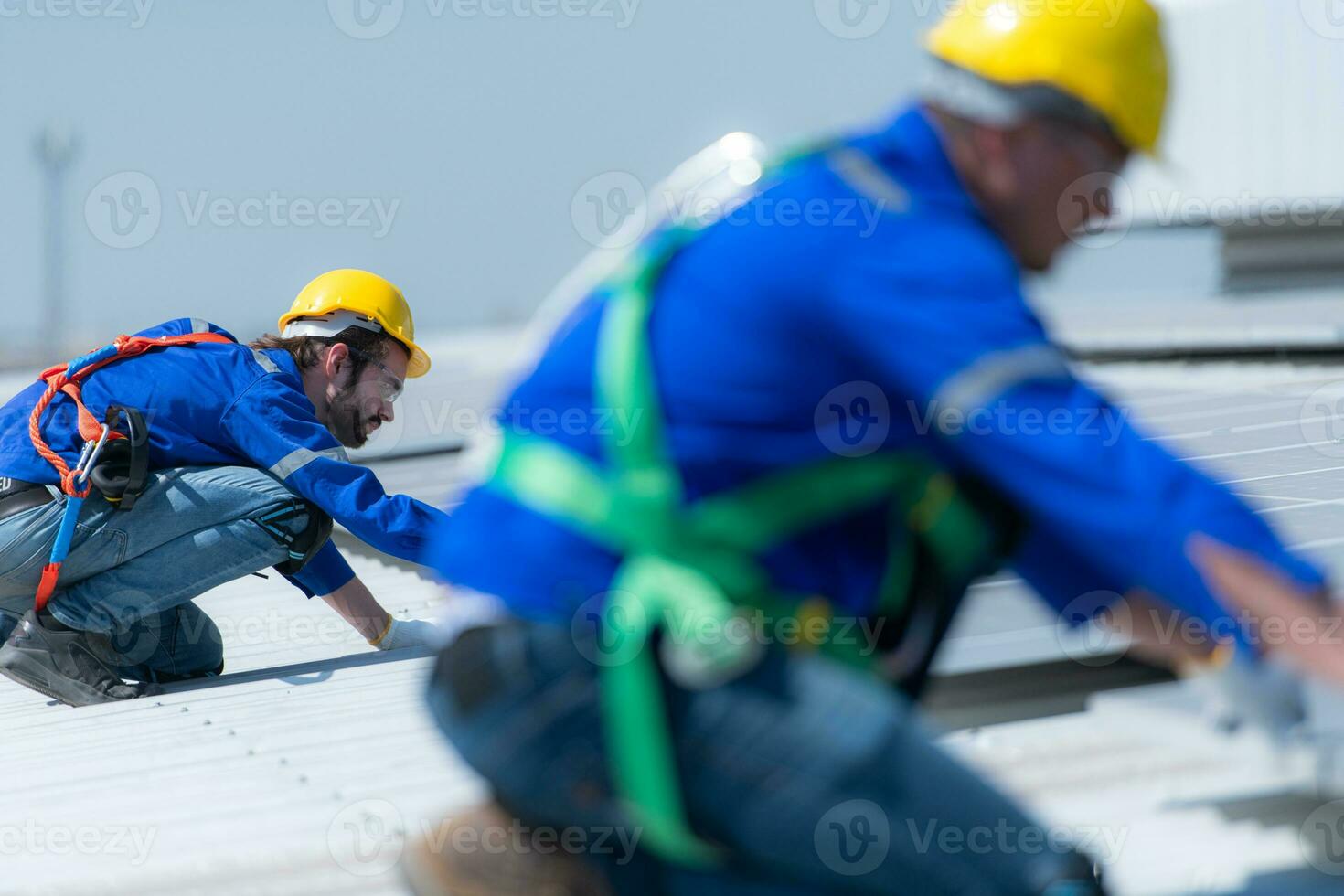 Both of technicians is installing solar panels on the roof of the warehouse to change solar energy into electrical energy for use in factories. photo