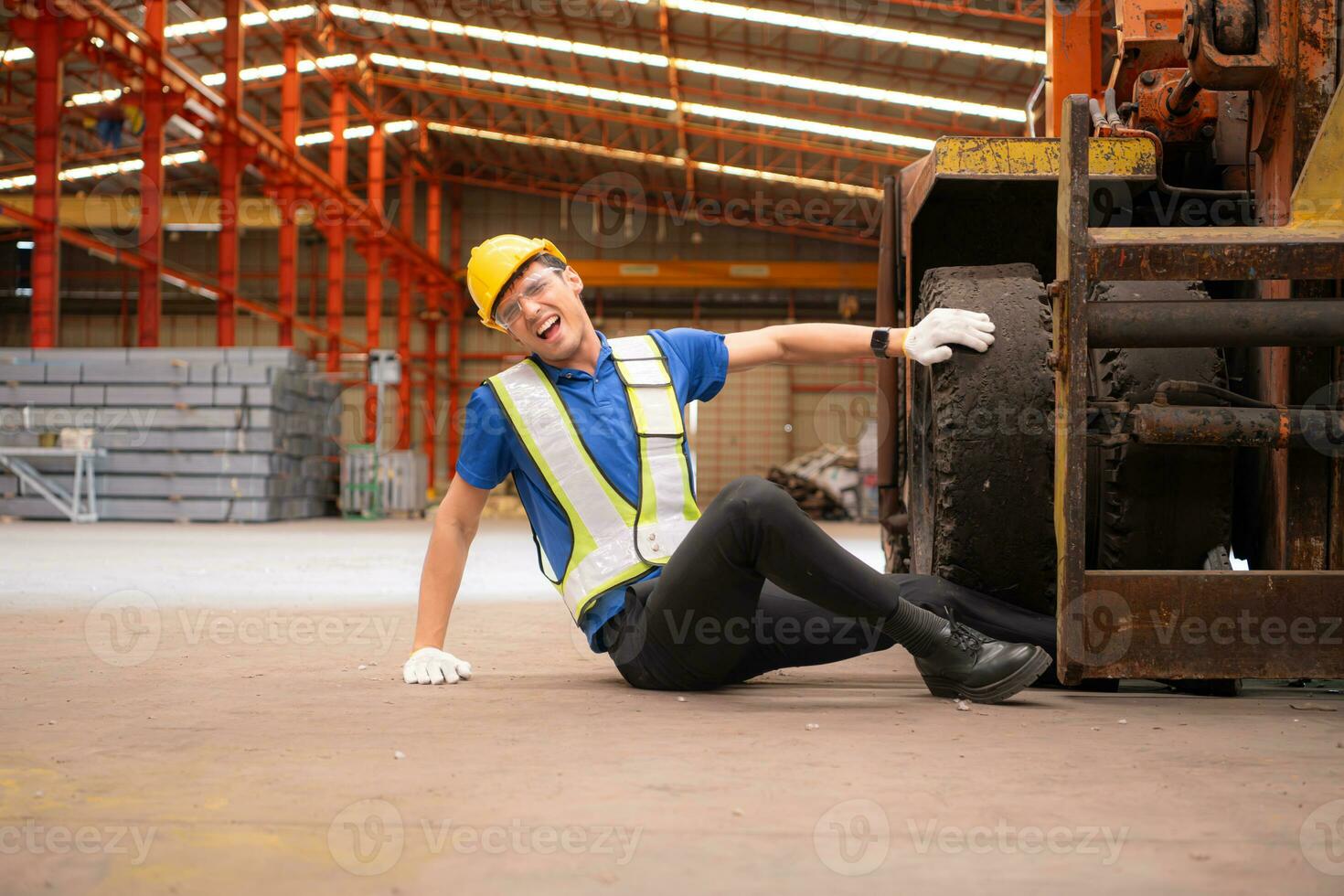 Young man working in a steel industry factory. He was critically hurt when a forklift ran over his leg and had to be transported to the hospital. photo