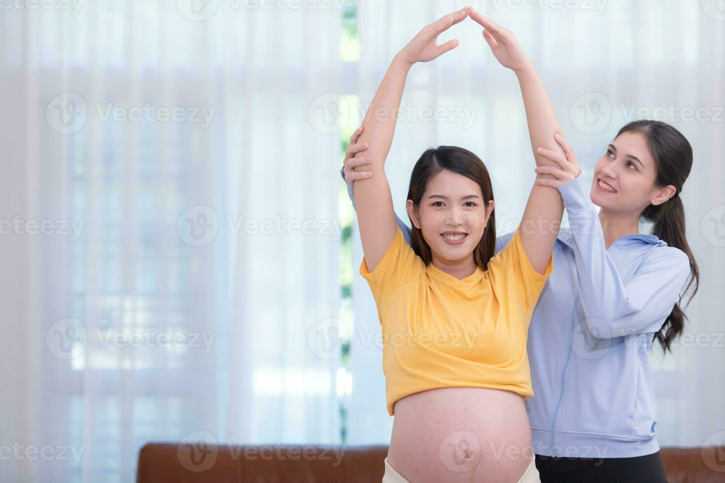 contento asiático embarazada mujer con yoga profesor enseñando el embarazo yoga en su vivo habitación. foto