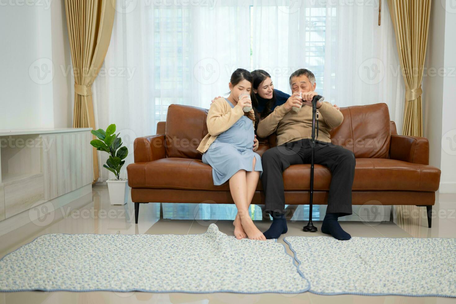 A happy family sits on the sofa in the living room, Father and daughter are pregnant drinking milk and talk to each other. photo