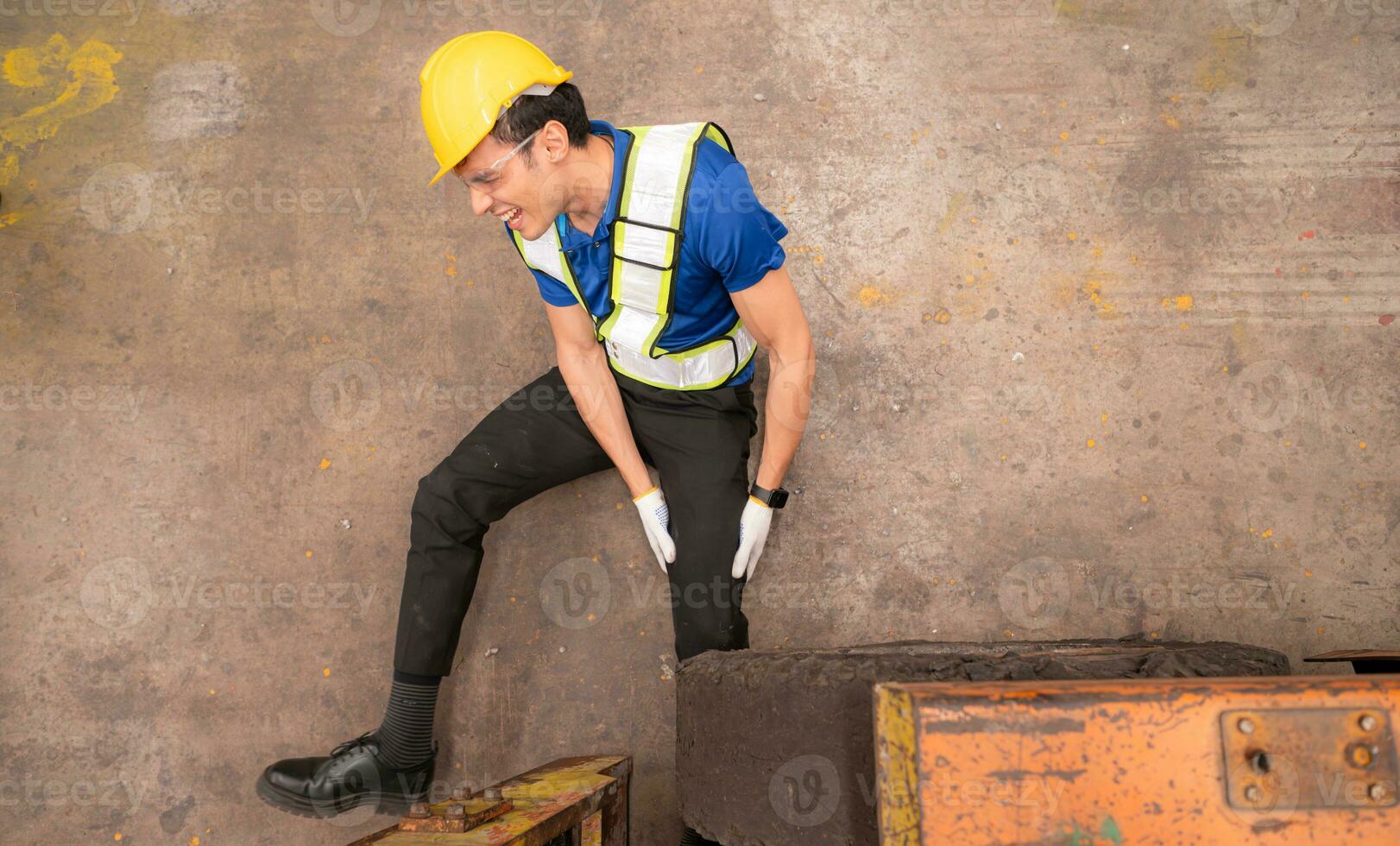 Young man working in a steel industry factory. He was critically hurt when a forklift ran over his leg and had to be transported to the hospital. photo