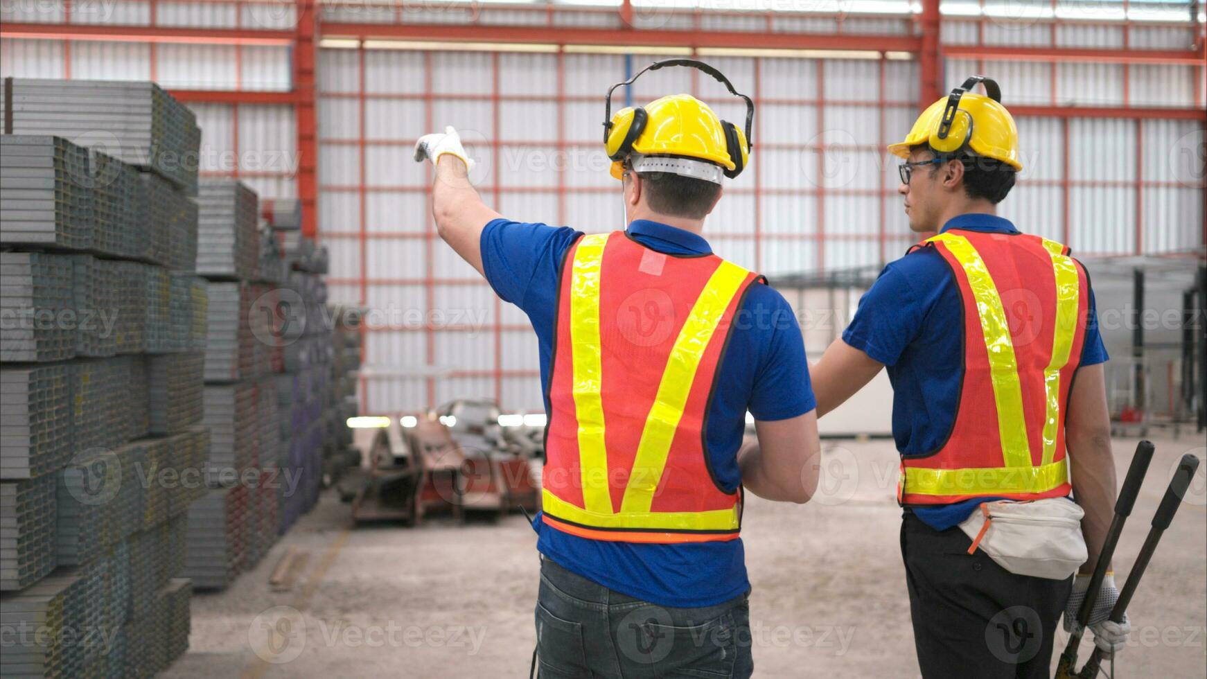 almacén trabajadores en difícil sombreros y cascos, inspeccionar y contar acero en el depósito. foto