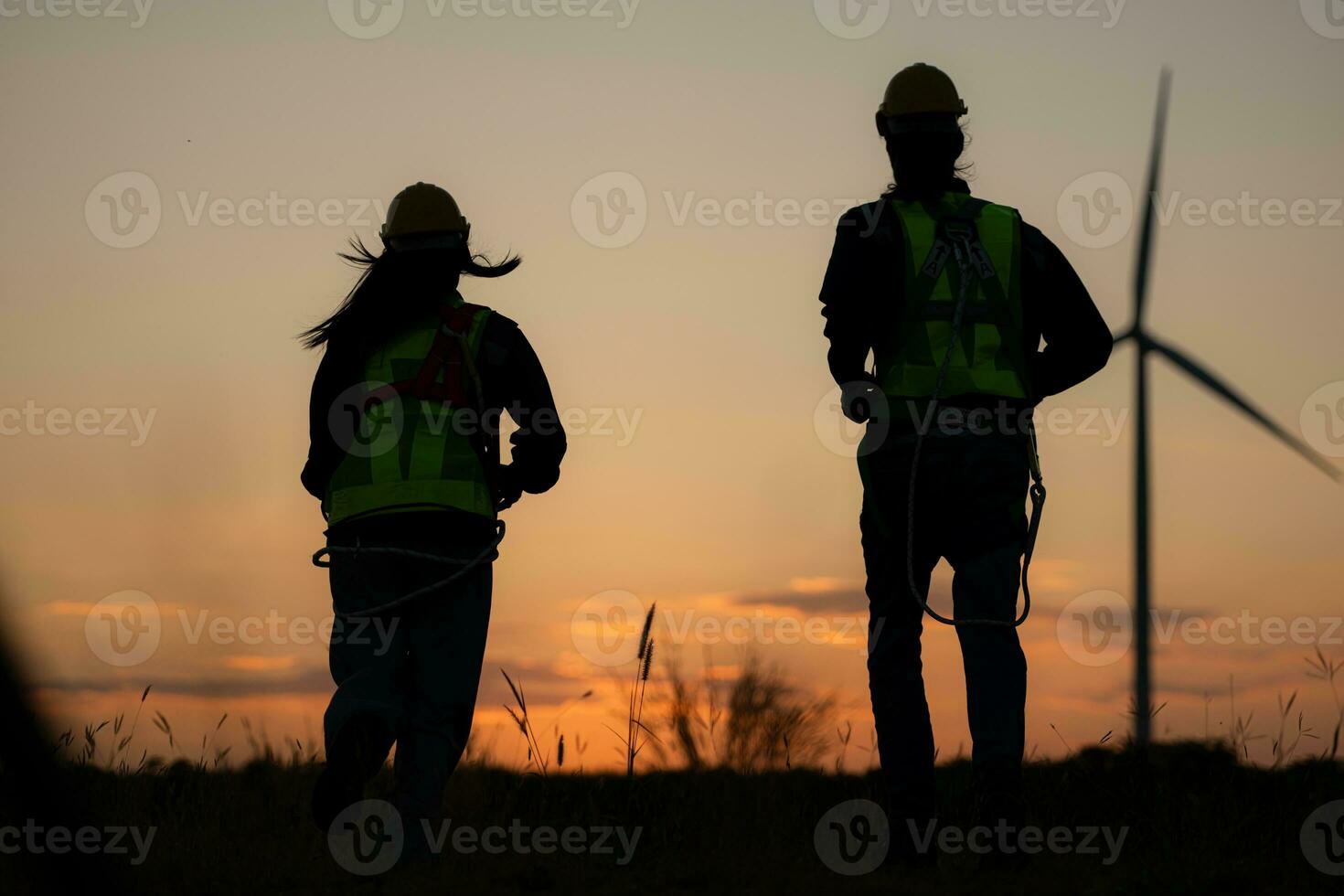 Silhouette of Engineer in charge of wind energy against a background of wind turbines. photo