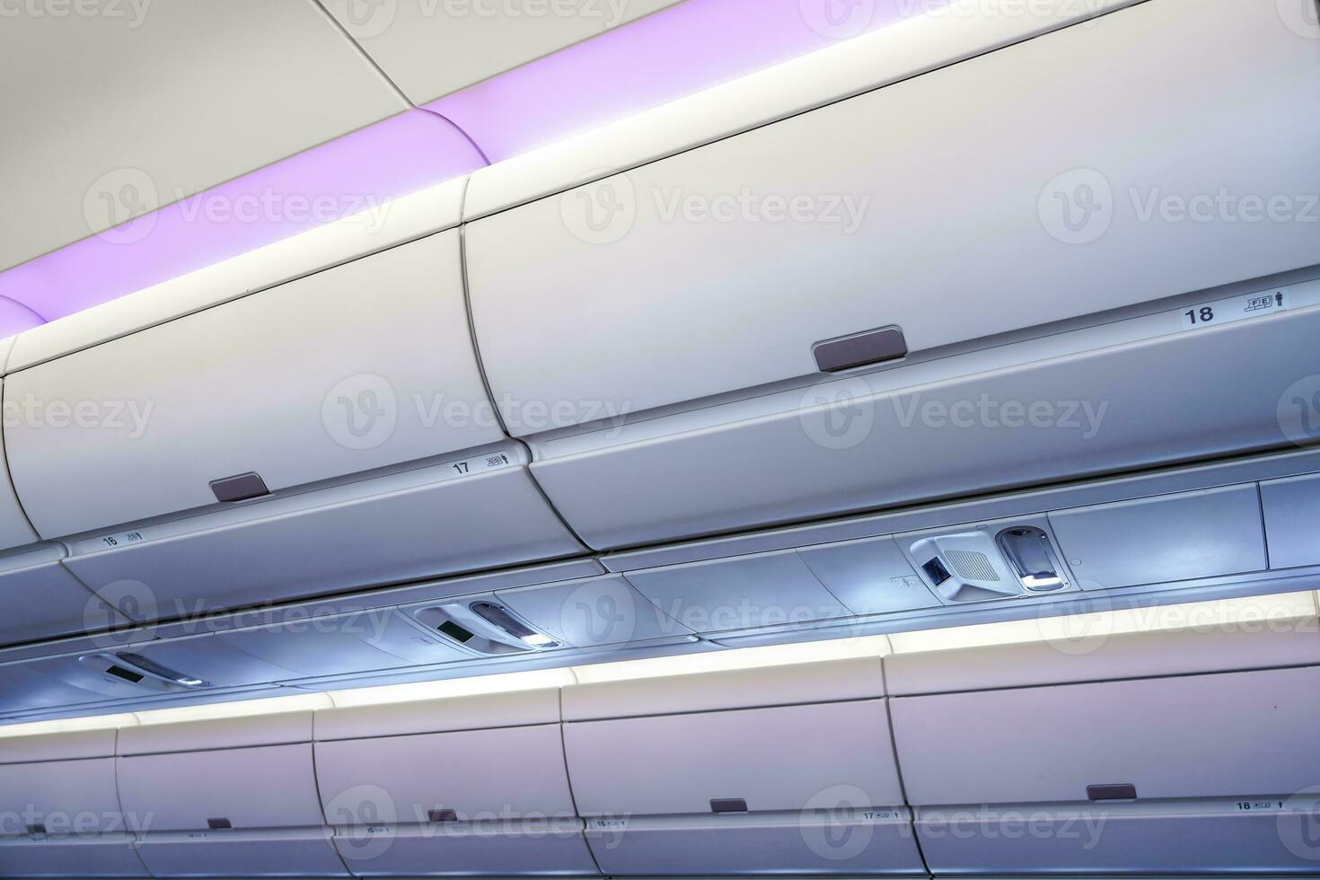 Carry-on luggage in overhead storage compartment on commercial airplane. photo