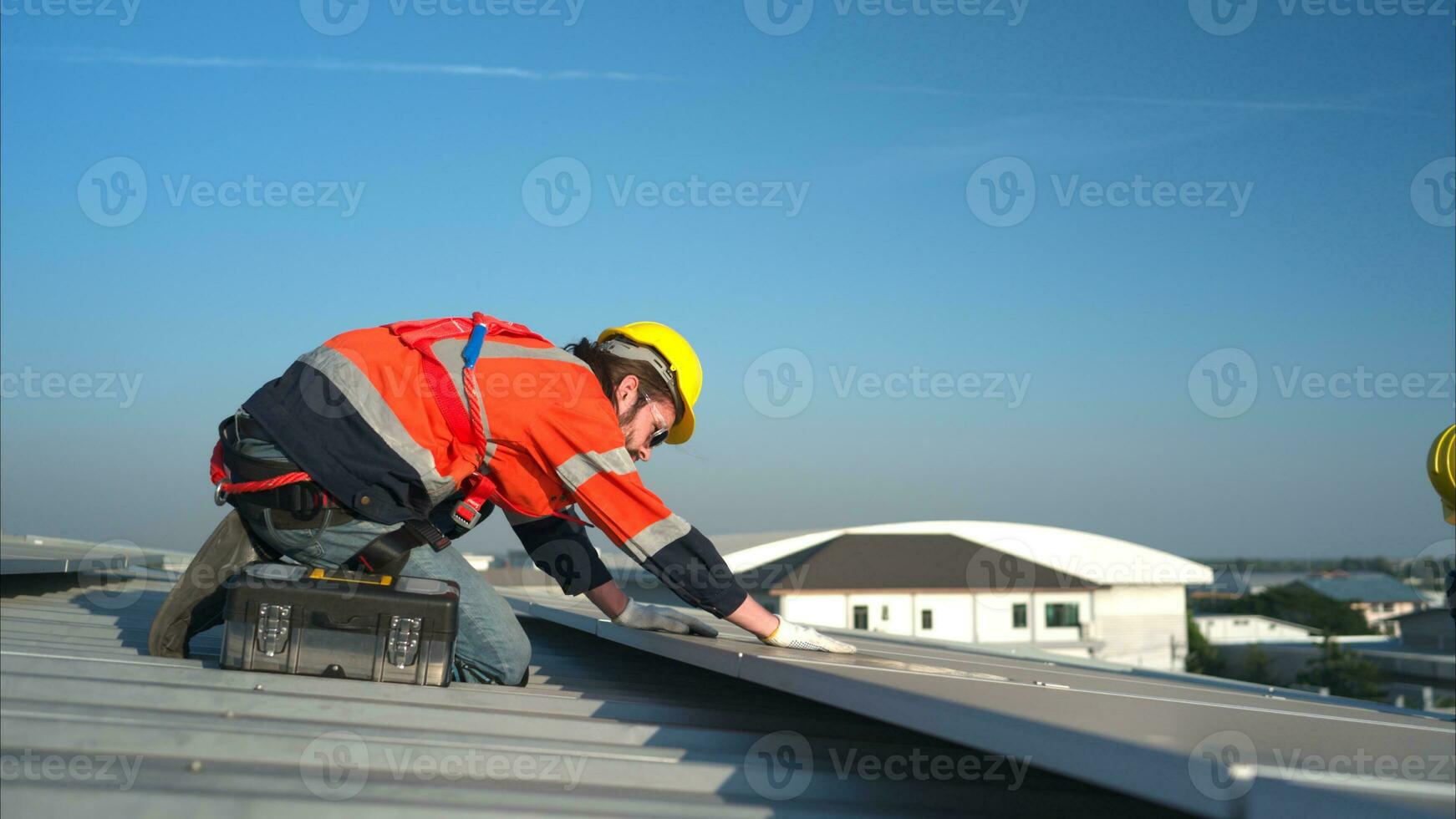 Both of technicians is installing solar panels on the roof of the warehouse to change solar energy into electrical energy for use in factories. photo