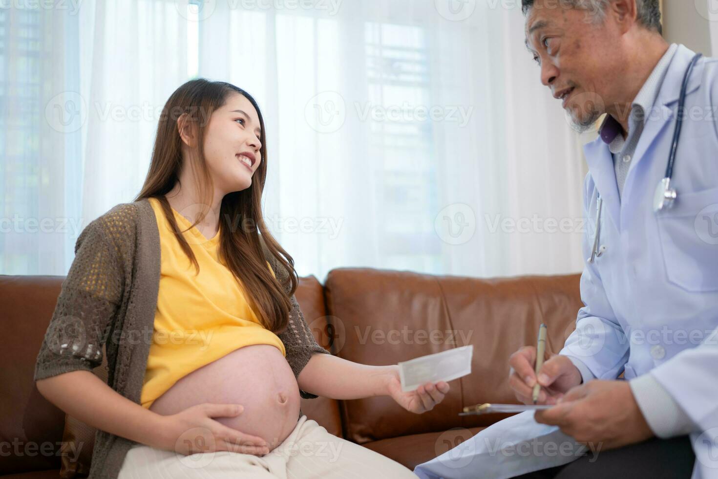 Asian pregnant woman visit gynecologist doctor at medical clinic for pregnancy consultant. Doctor examine pregnant belly for baby and mother healthcare check up. photo