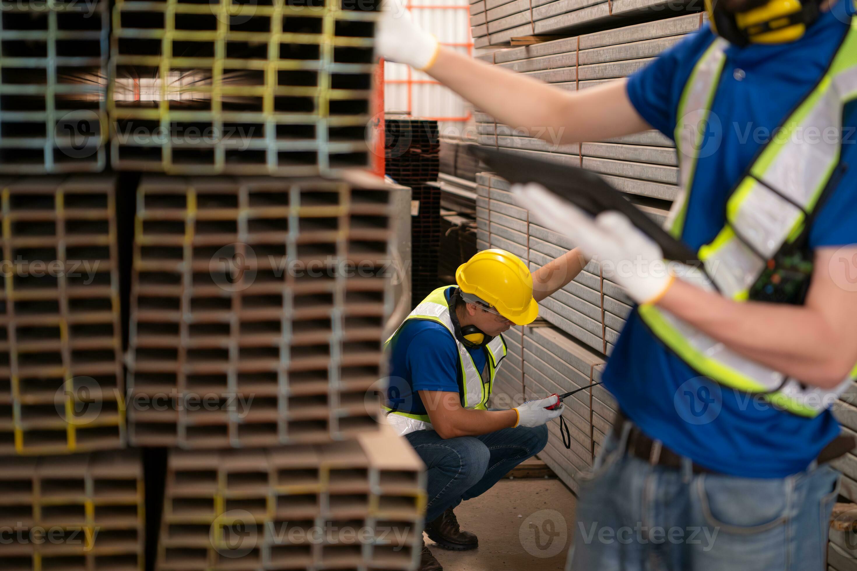 Warehouse worker in hard hats and helmets stand in the warehouse to