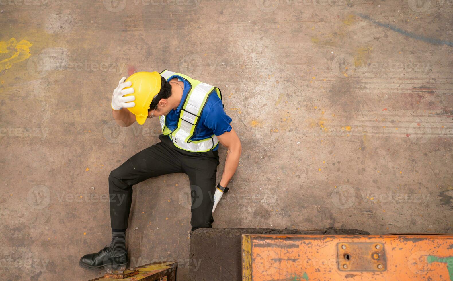 Young man working in a steel industry factory. He was critically hurt when a forklift ran over his leg and had to be transported to the hospital. photo