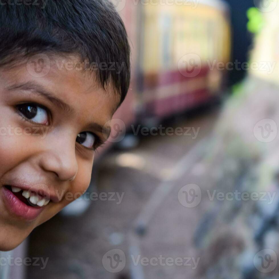 pequeño chico de viaje en juguete tren Moviente en montaña pendientes, hermosa vista, uno lado montaña, uno lado Valle Moviente en ferrocarril a el colina, entre verde natural bosque. juguete tren shimla foto