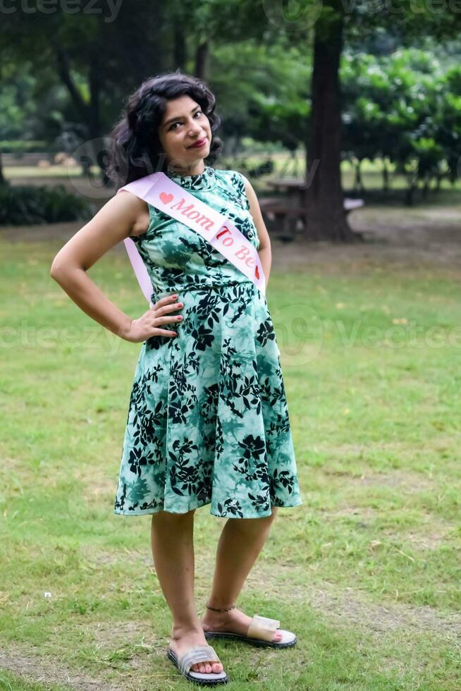 A pregnant Indian lady poses for outdoor pregnancy shoot and hands on  belly, Indian pregnant woman