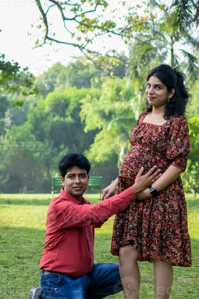 indio Pareja posando para maternidad disparar actitud para acogedor nuevo nacido bebé en lodhi la carretera en Delhi India, maternidad foto disparar hecho por padres para acogedor su niño, pre bebé foto disparar