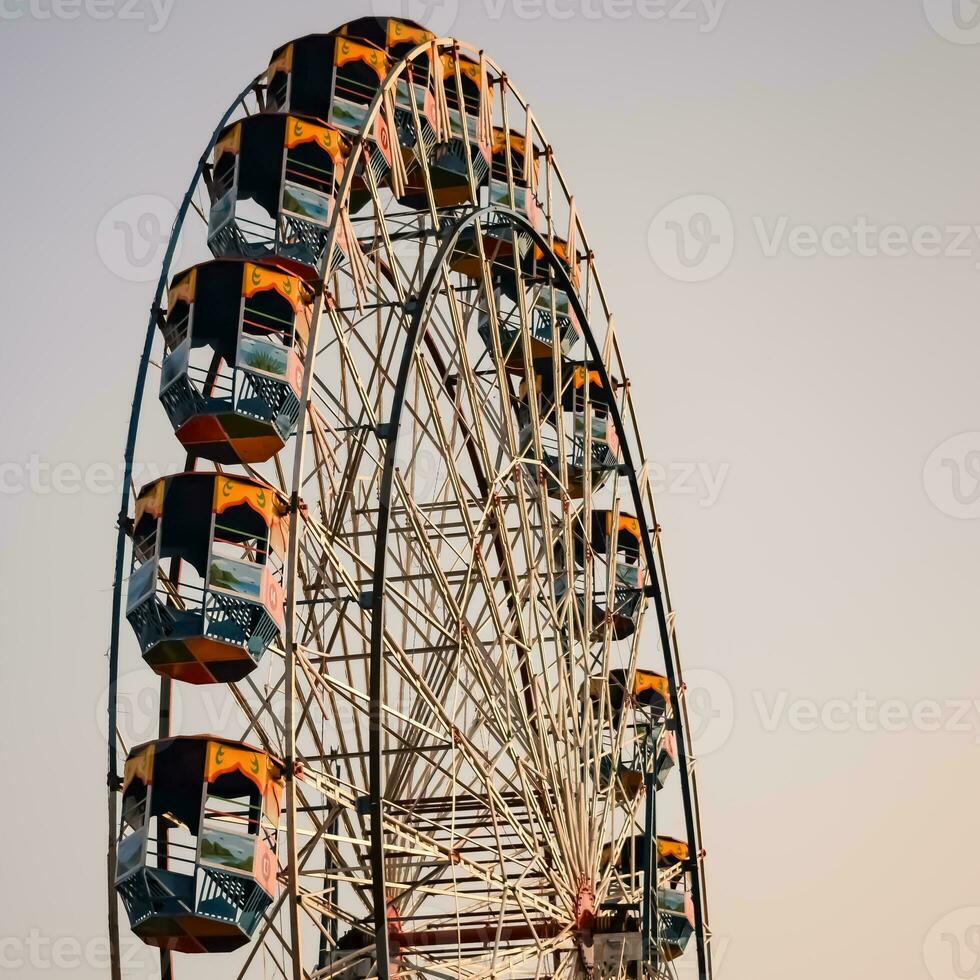 Closeup of multi-coloured Giant Wheel during Dussehra Mela in Delhi, India. Bottom view of Giant Wheel swing. Ferriswheel with colourful cabins during day time. photo