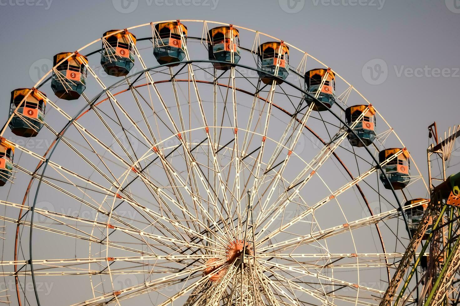 Closeup of multi-coloured Giant Wheel during Dussehra Mela in Delhi, India. Bottom view of Giant Wheel swing. Ferriswheel with colourful cabins during day time. photo