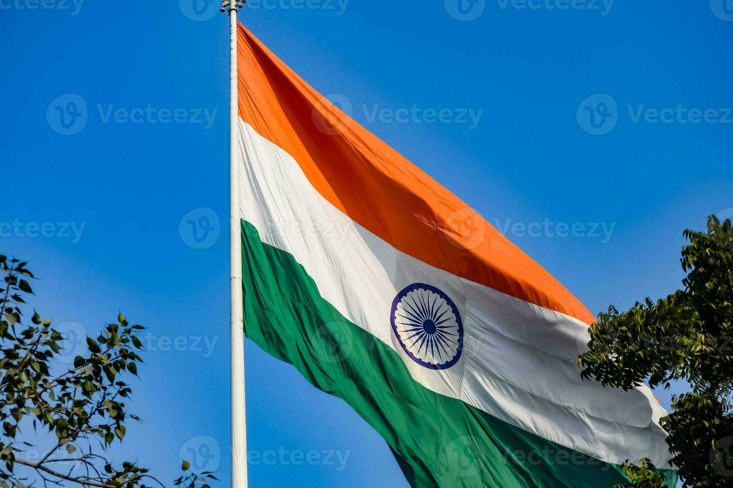 India flag flying high at Connaught Place with pride in blue sky, India flag fluttering, Indian Flag on Independence Day and Republic Day of India, tilt up shot, Waving Indian flag, Har Ghar Tiranga photo