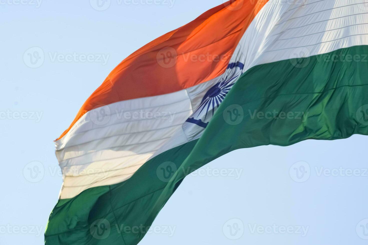 India flag flying high at Connaught Place with pride in blue sky, India flag fluttering, Indian Flag on Independence Day and Republic Day of India, tilt up shot, Waving Indian flag, Har Ghar Tiranga photo