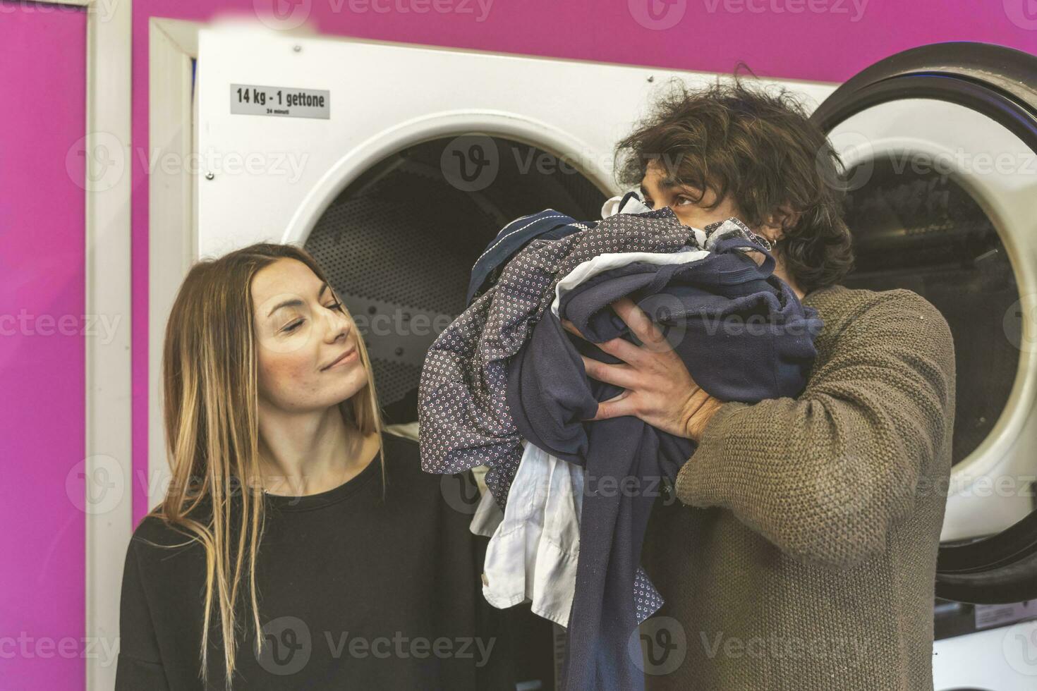 young couple of lovers are smelling the freshly washed scented clothes photo