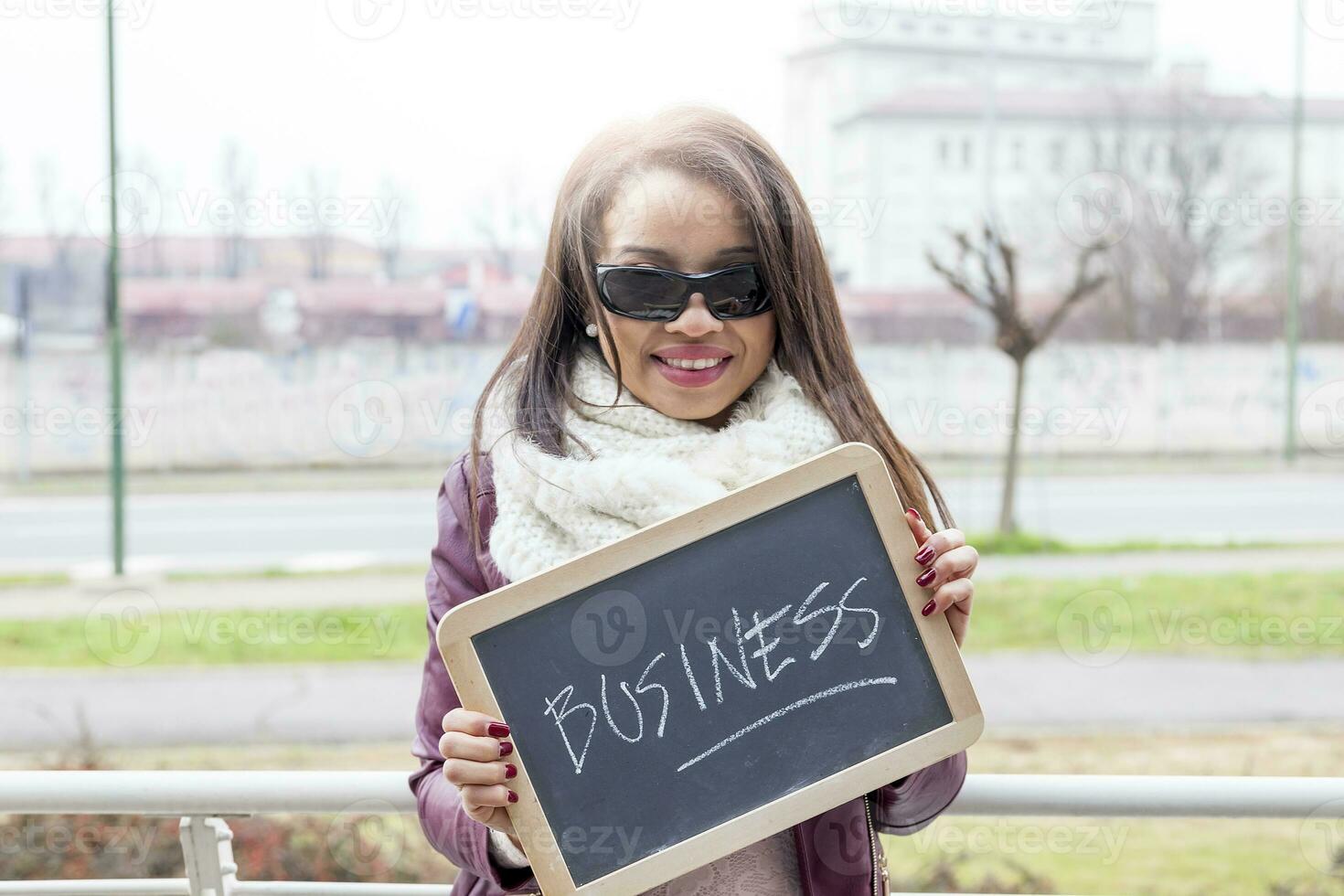 young attractive businesswoman shows a blackboard marked with business concepts photo