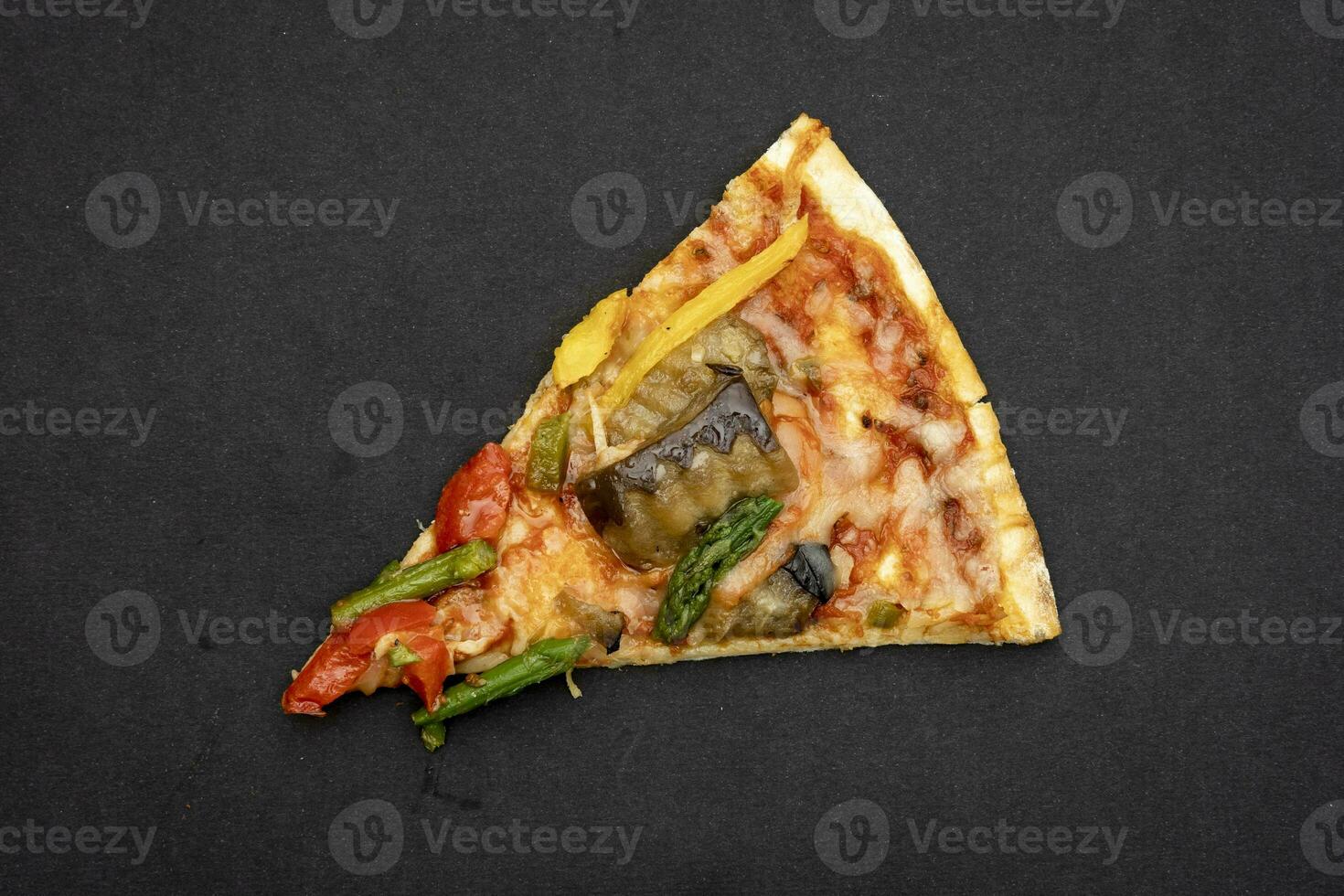 slice of tasty grilled vegetable pizza cooked with ingredients on black background. photo