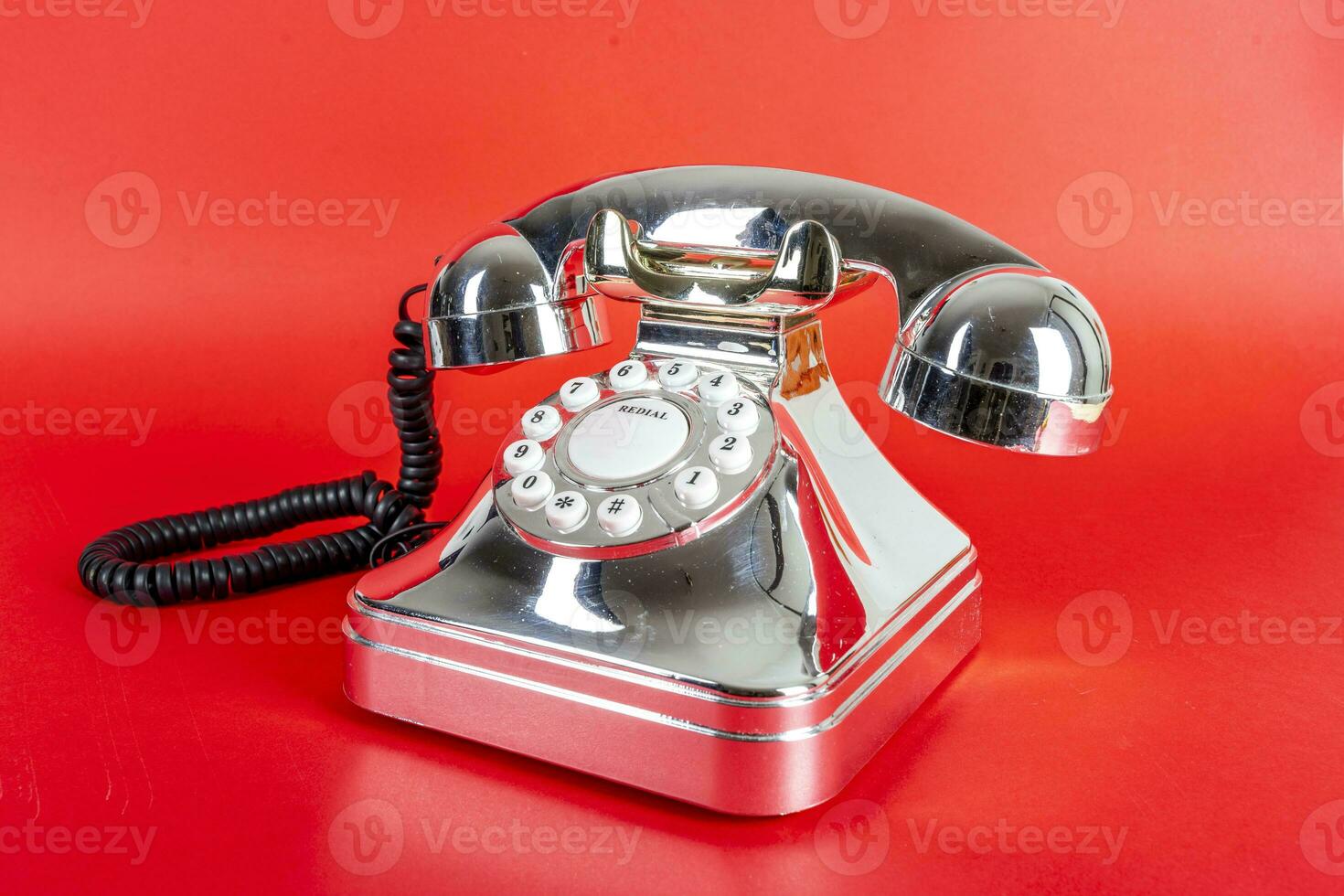 chrome vintage telephone on a red background photo
