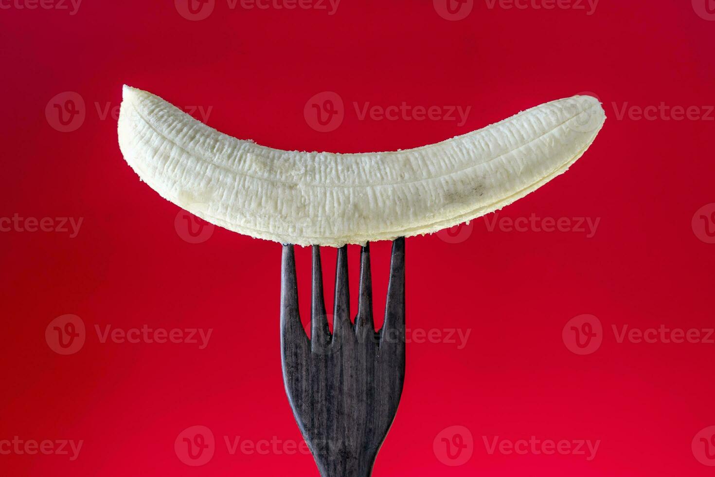 peeled banana skewered on a wooden fork photo