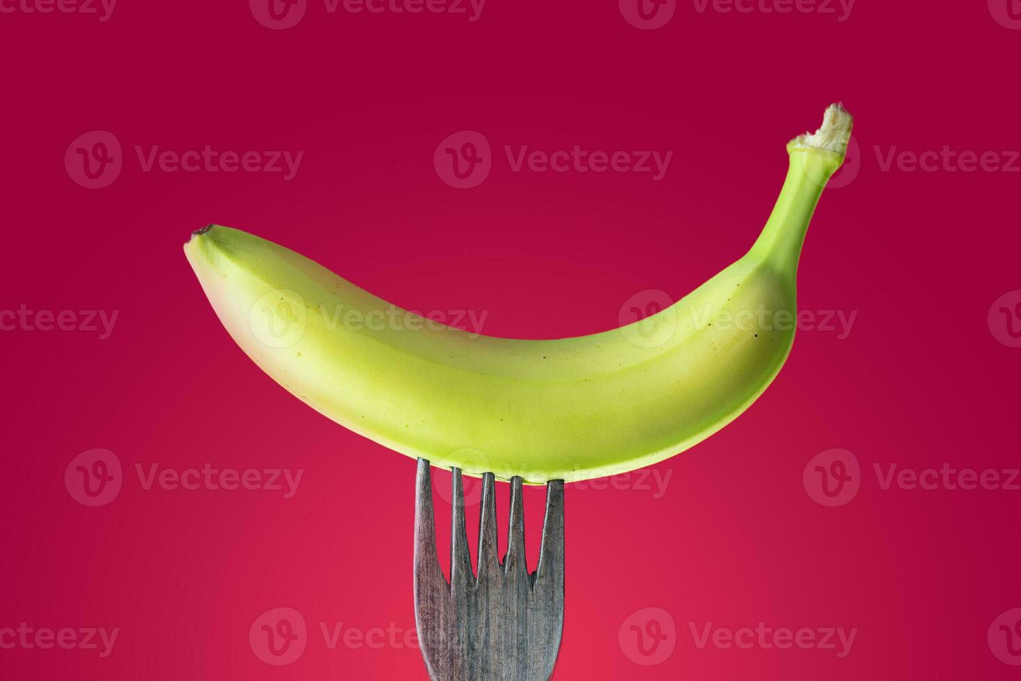 banana with peel skewered on a wooden fork photo