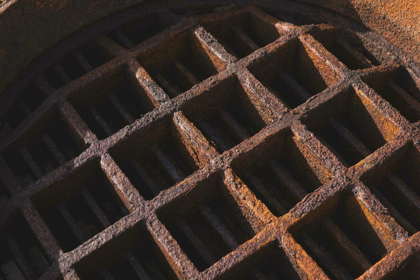 Background of the old backside rusty manhole cover with light and shadow on surface photo
