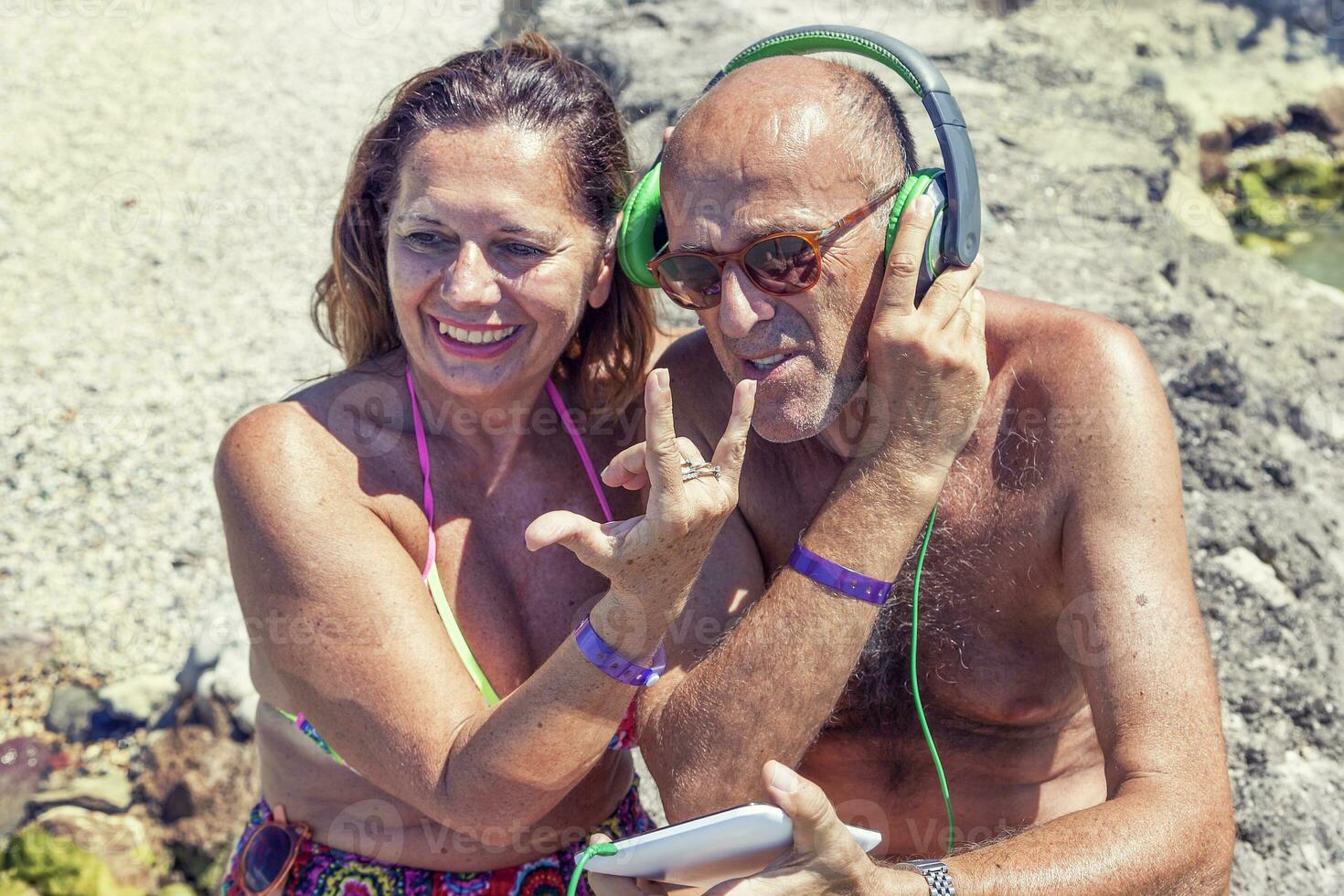 modern mature couple listening to music with headphones photo