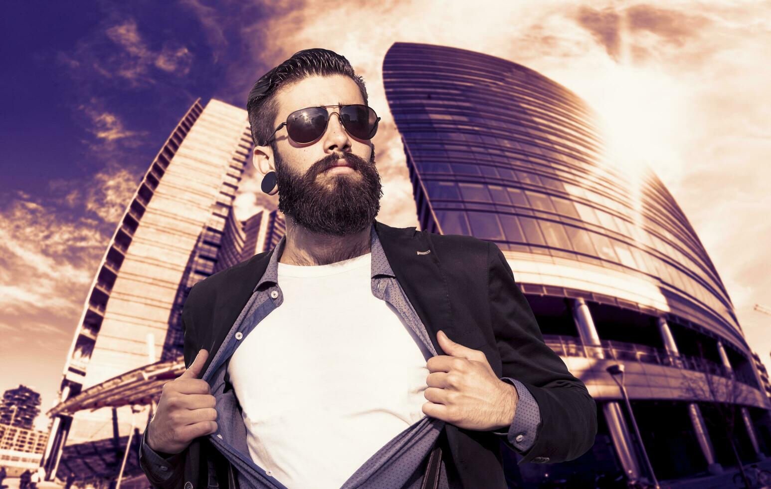 young hipster superhero is protecting the city in front of a skyscraper photo