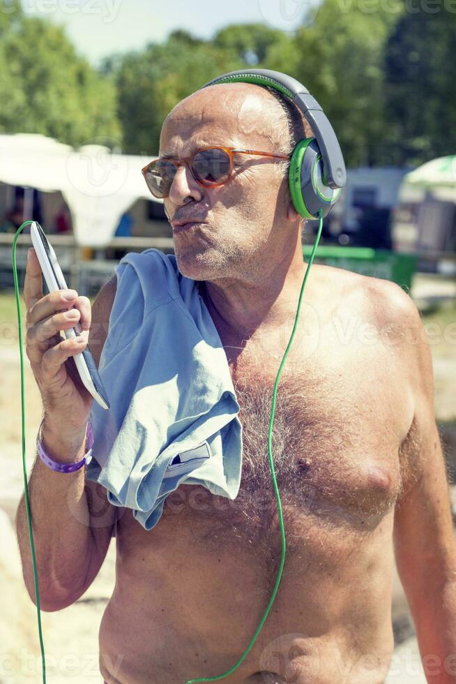 Mature modern man listens to music with headphones photo