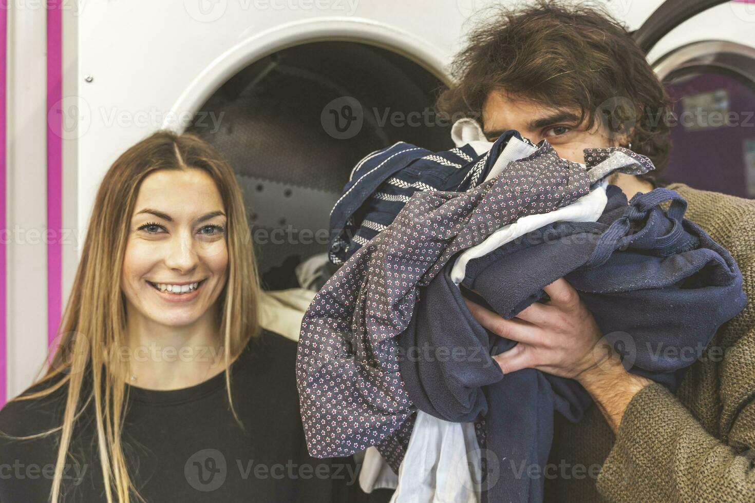 young couple of lovers are smelling the freshly washed scented clothes photo