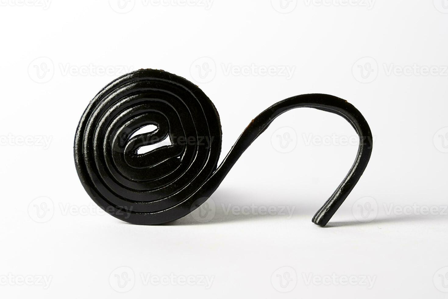 Roll spiral of black licorice isolated on white photo