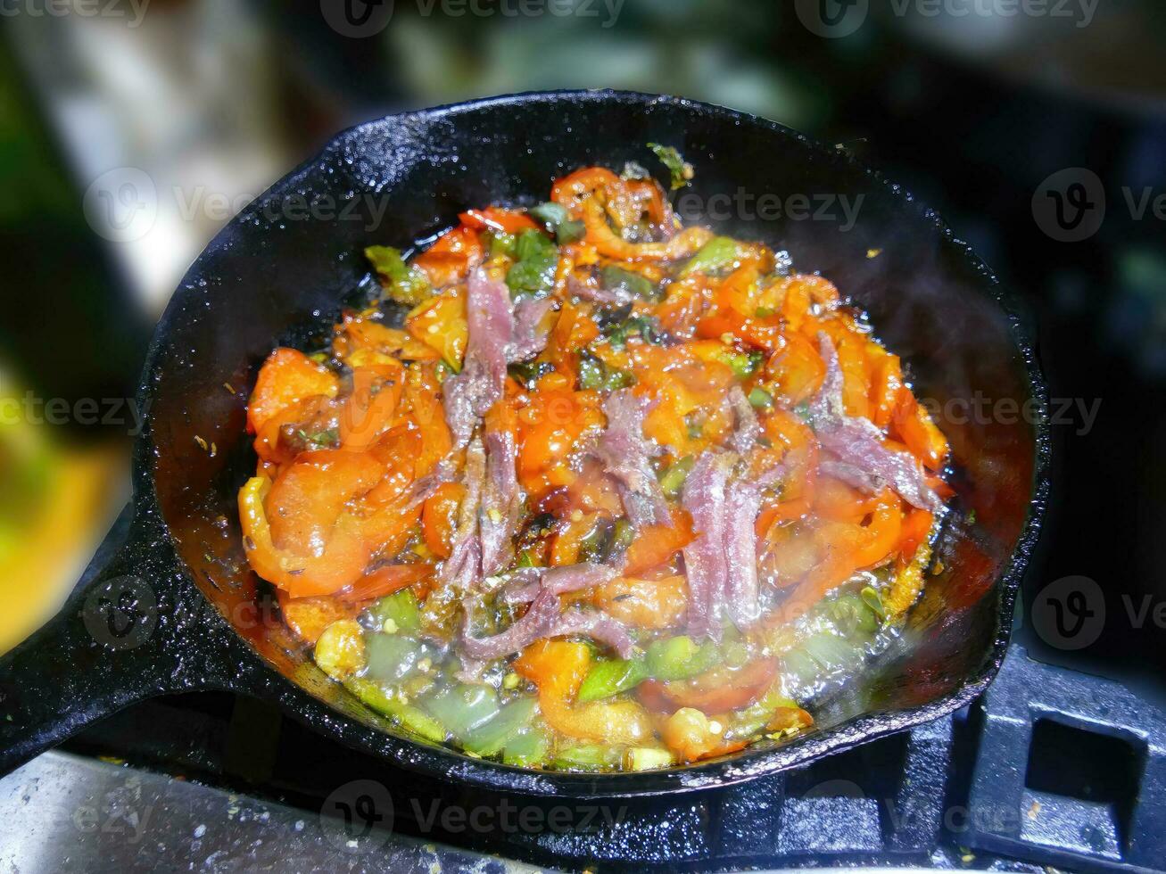 Anchovies added to saute of red bell pepers and jalapenos photo