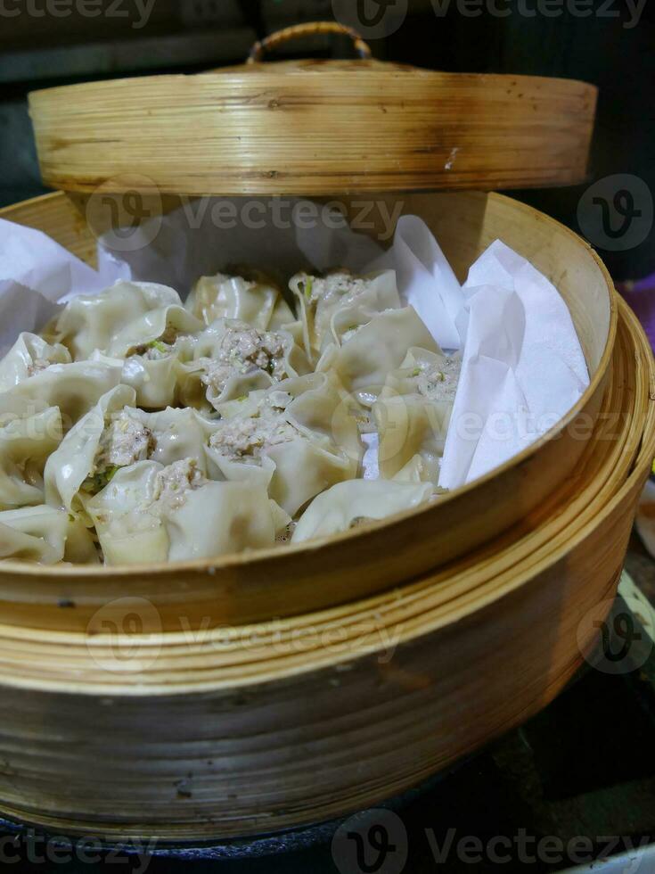 Steaming shumai dim sum in a bamboo steamer photo