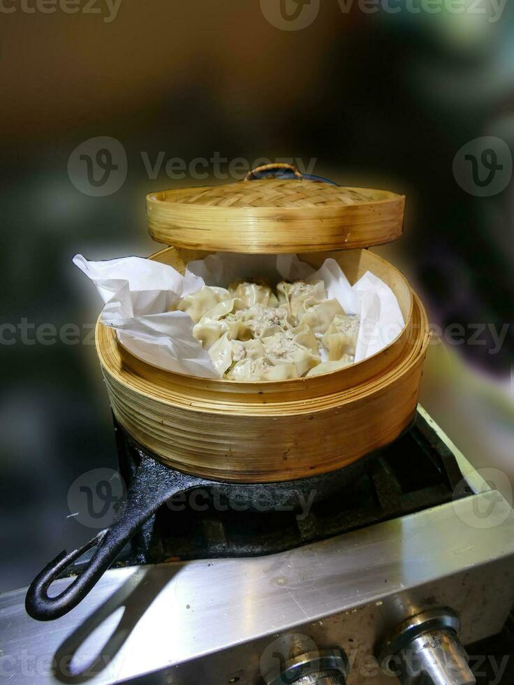 Steaming shumai dim sum in a bamboo steamer photo
