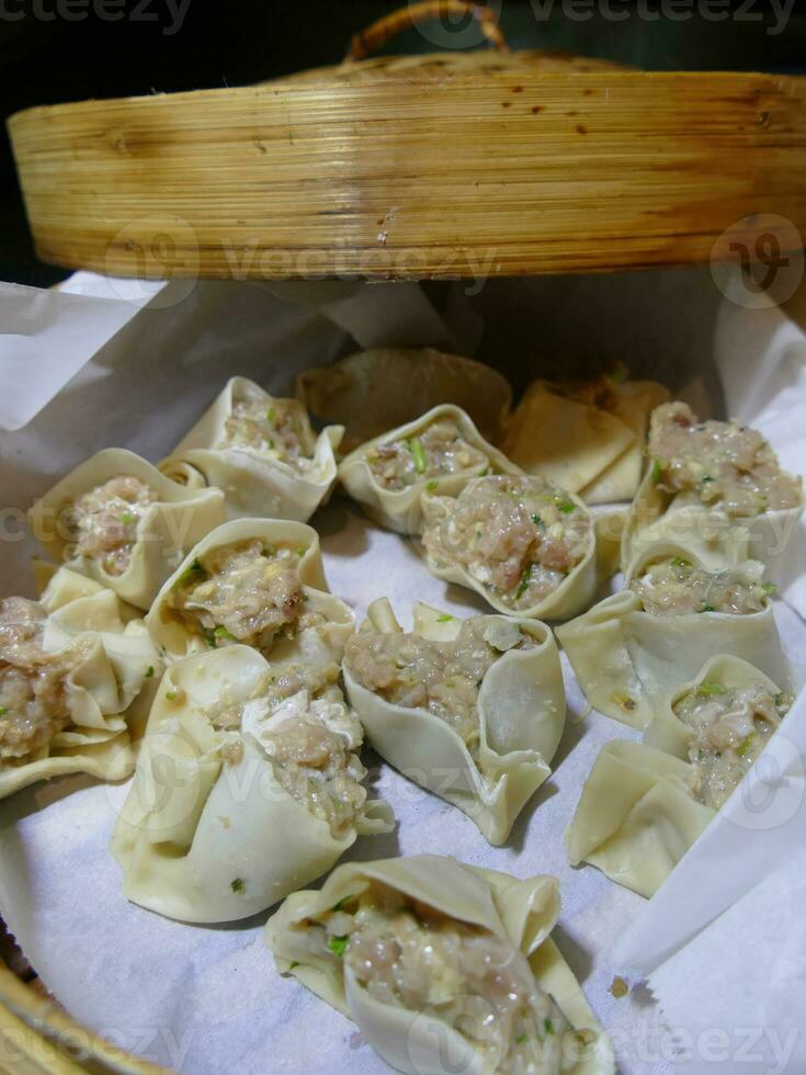 Steaming shumai dim sum in a bamboo steamer photo