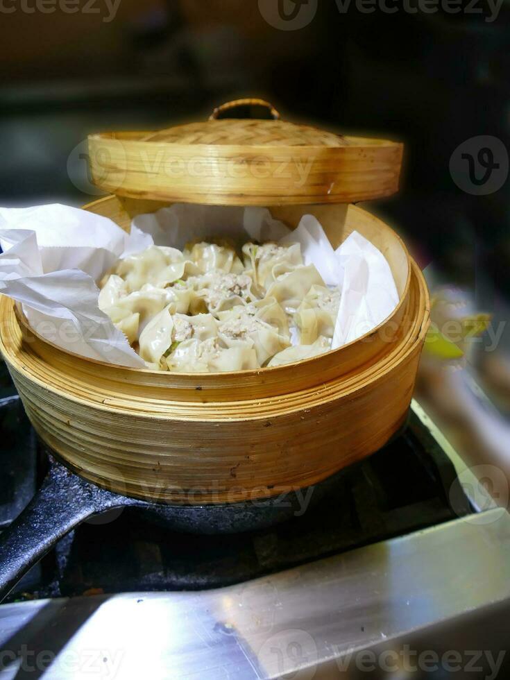 Steaming shumai dim sum in a bamboo steamer photo