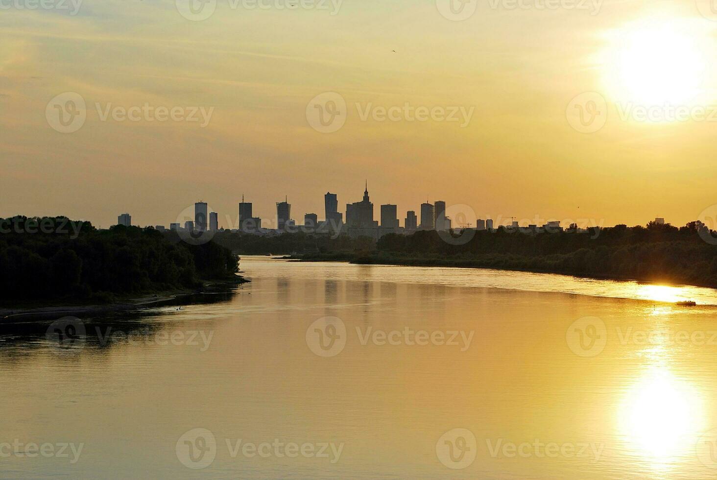 River in the city in at colorful sunset in the background photo