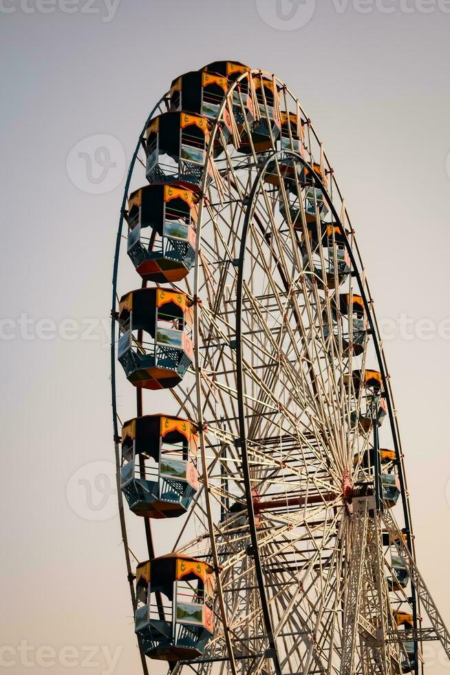 Closeup of multi-coloured Giant Wheel during Dussehra Mela in Delhi, India. Bottom view of Giant Wheel swing. Ferriswheel with colourful cabins during day time. photo