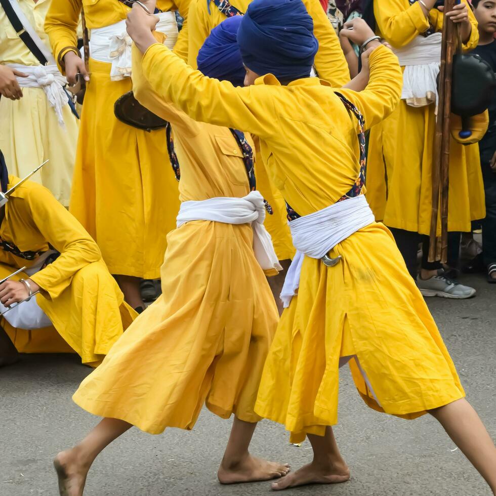 Delhi, India, October 2, 2023 - Sikhs display gatka and martial arts during annual Nagar Kirtan, Traditional, procession on account of birthday of Guru Nanak Dev ji, Nagar Kirtan in East Delhi area photo