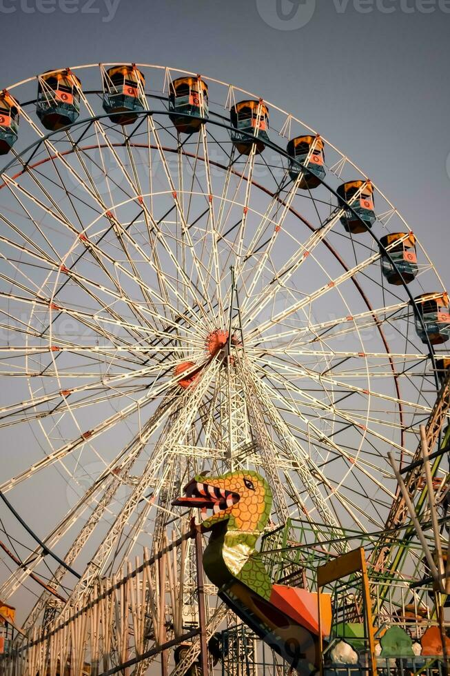 Closeup of multi-coloured Giant Wheel during Dussehra Mela in Delhi, India. Bottom view of Giant Wheel swing. Ferriswheel with colourful cabins during day time. photo