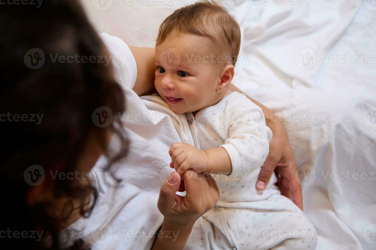 View from above of a Latin American woman embracing her newborn baby boy, holding him in her arms photo