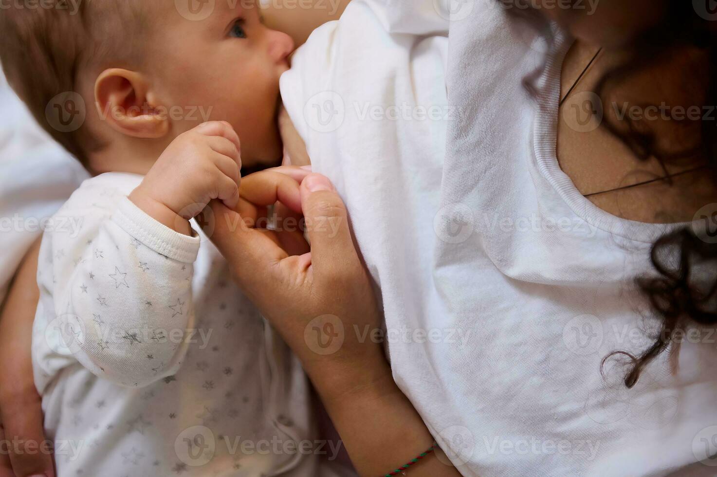 Close-up of a loving caring mother breastfeeding her baby boy. View from above photo